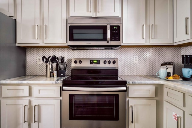 kitchen with stainless steel appliances, light stone countertops, and backsplash