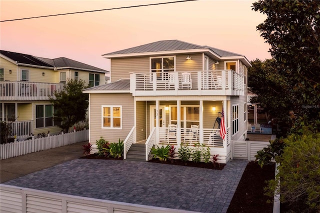 view of property with a balcony and a porch