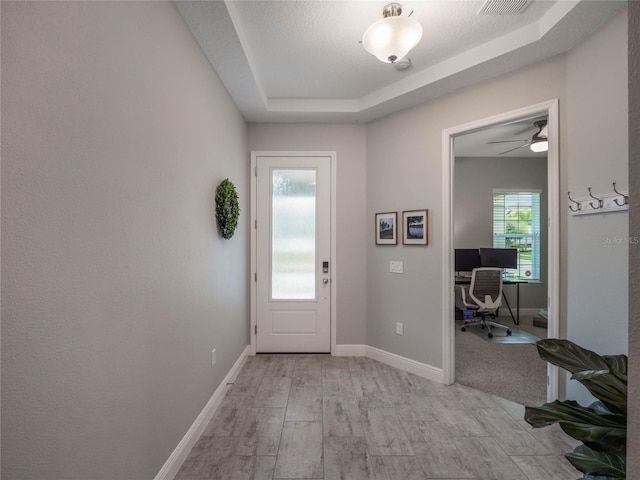 entryway featuring a textured ceiling and a raised ceiling