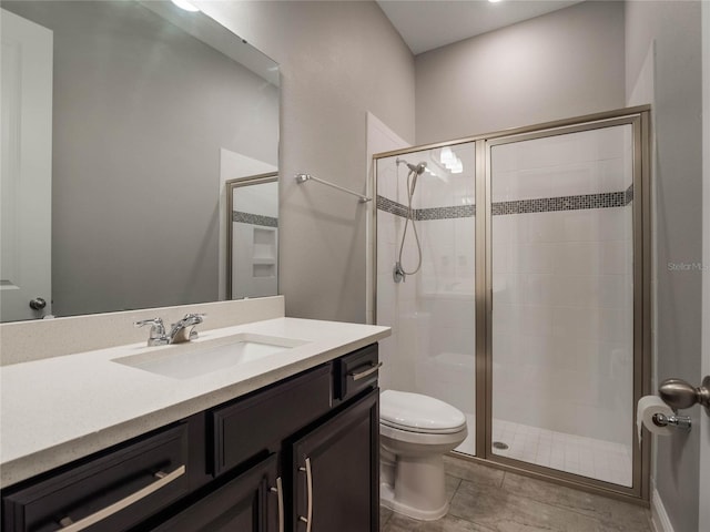 bathroom with toilet, a shower with shower door, and vanity