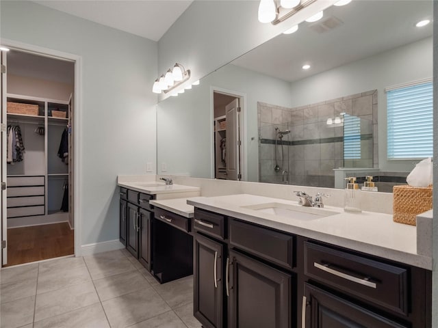 bathroom with tiled shower, tile patterned floors, and vanity