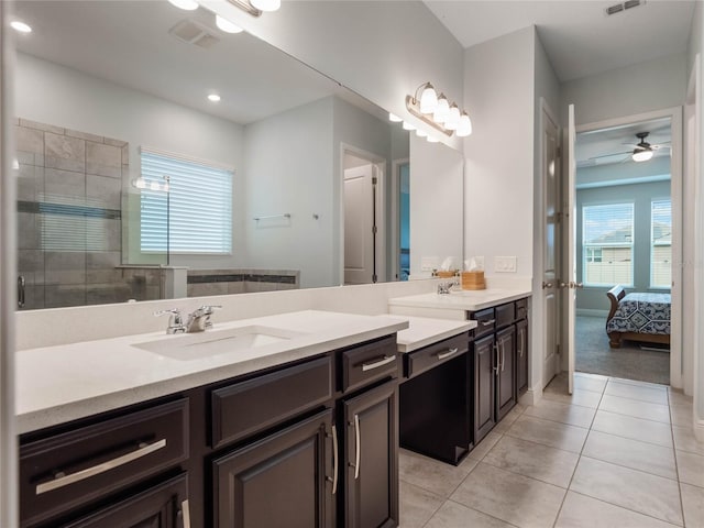 bathroom with vanity, ceiling fan, tiled shower, and tile patterned flooring