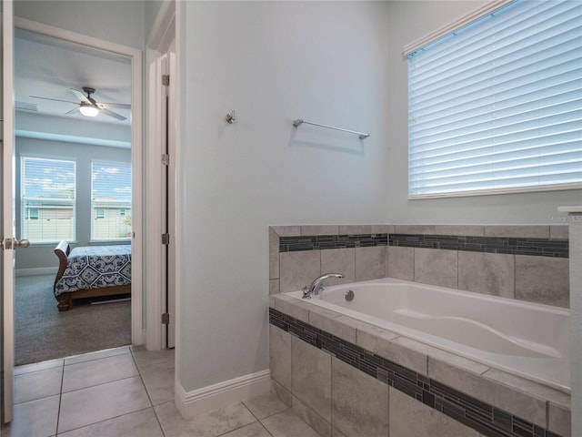 bathroom with ceiling fan, tiled tub, and tile patterned floors