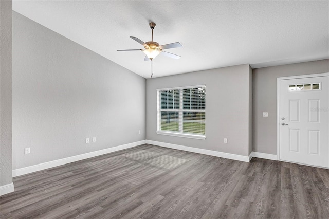 entryway featuring ceiling fan, a healthy amount of sunlight, dark wood-type flooring, and a textured ceiling