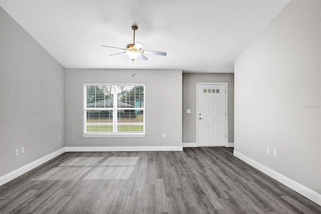 spare room with a textured ceiling, ceiling fan, and dark hardwood / wood-style flooring