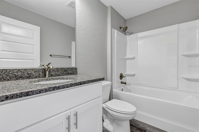 full bathroom featuring hardwood / wood-style flooring, toilet, vanity, and bathing tub / shower combination