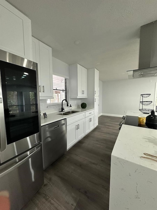 kitchen featuring wall chimney range hood, sink, white cabinetry, stainless steel appliances, and dark hardwood / wood-style flooring