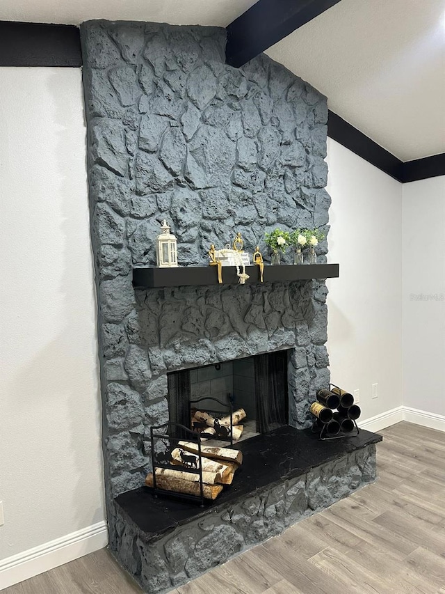 interior details featuring wood-type flooring, a fireplace, and beamed ceiling