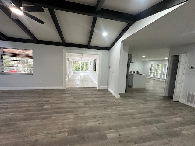 interior space featuring ceiling fan, wood-type flooring, and lofted ceiling with beams