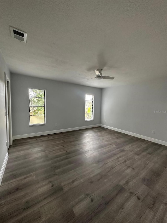 empty room with ceiling fan and dark hardwood / wood-style floors