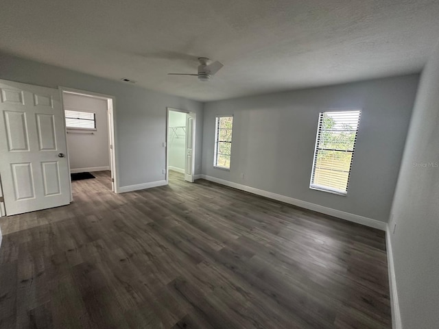 empty room with ceiling fan and dark hardwood / wood-style flooring