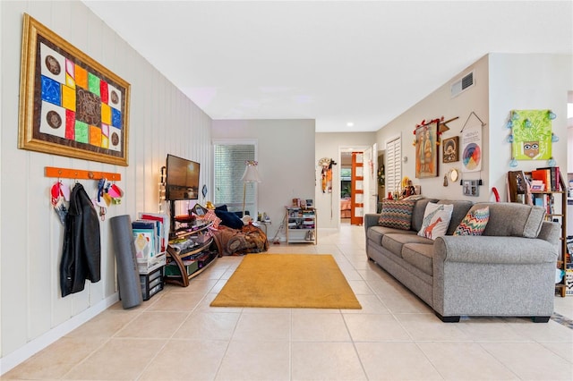 living room featuring light tile patterned floors and wood walls