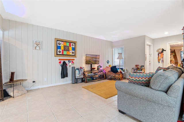 living room featuring wood walls and light tile patterned flooring