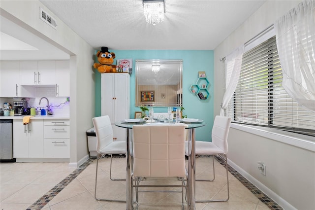 tiled dining area with a textured ceiling and sink