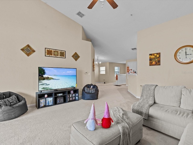 carpeted living room featuring vaulted ceiling and ceiling fan with notable chandelier