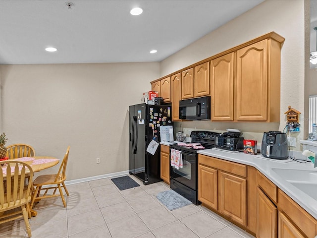 kitchen with sink, light tile patterned floors, and black appliances