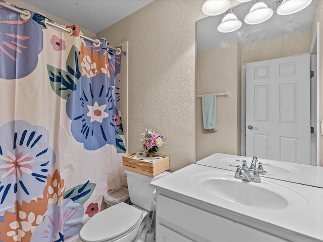 bathroom with vanity, toilet, a textured ceiling, and a shower with shower curtain