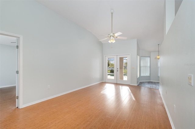 unfurnished living room featuring ceiling fan, light hardwood / wood-style floors, french doors, and high vaulted ceiling