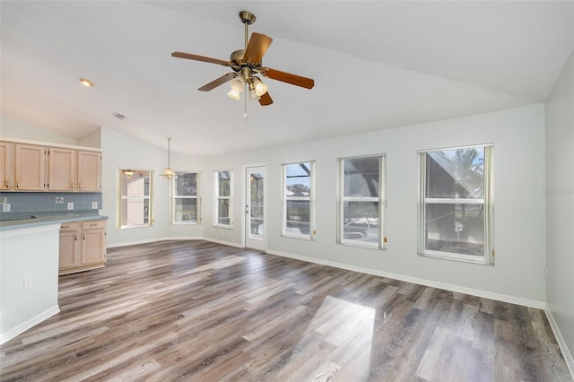 unfurnished living room featuring lofted ceiling, ceiling fan, and dark hardwood / wood-style flooring