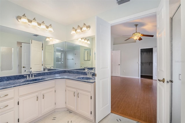 bathroom with ceiling fan, vanity, a shower with door, and tile patterned floors