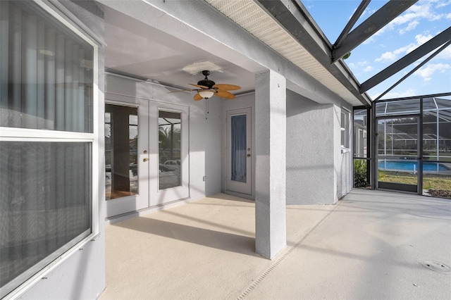 view of patio with ceiling fan, glass enclosure, and french doors