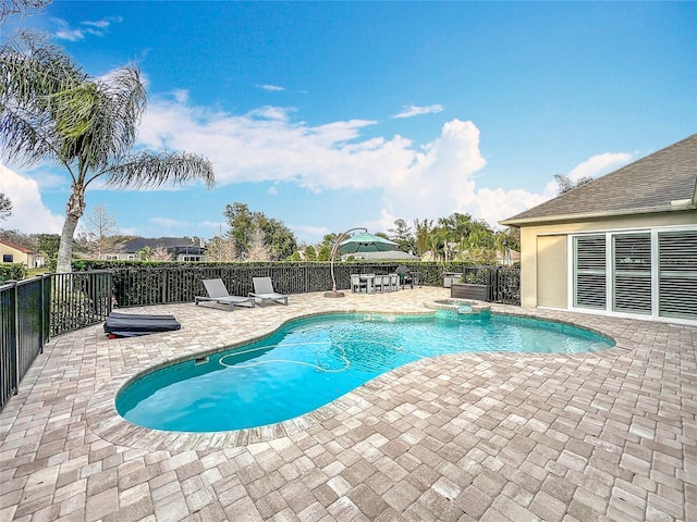 view of swimming pool featuring a patio area and an in ground hot tub