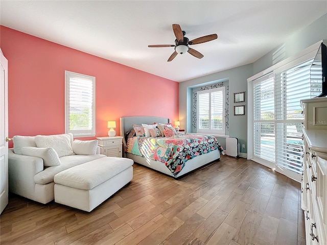 bedroom featuring ceiling fan, access to exterior, and light hardwood / wood-style flooring