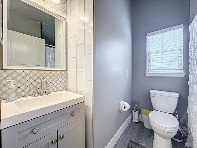 bathroom featuring backsplash, toilet, vanity, and hardwood / wood-style floors