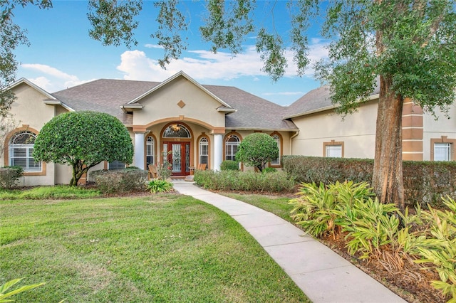 view of front of house with a front lawn and french doors