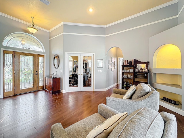 living room with french doors, dark hardwood / wood-style flooring, a high ceiling, and ornamental molding