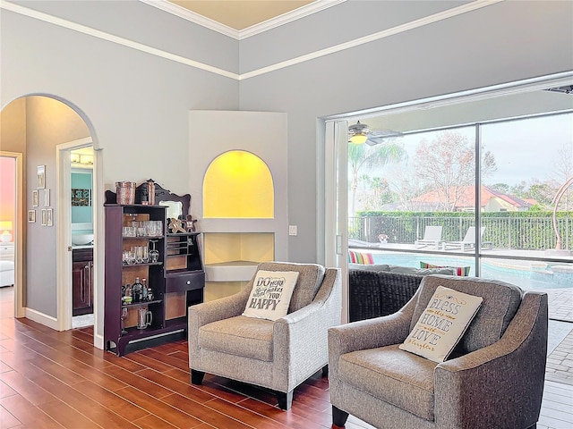 sitting room with dark wood-type flooring, ceiling fan, plenty of natural light, and ornamental molding