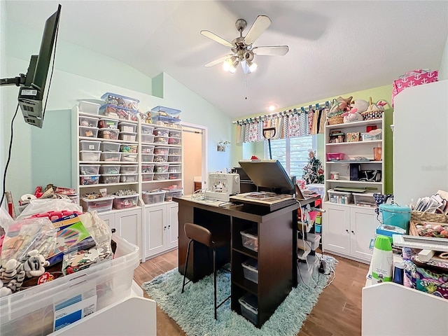 home office with ceiling fan, light hardwood / wood-style flooring, and vaulted ceiling