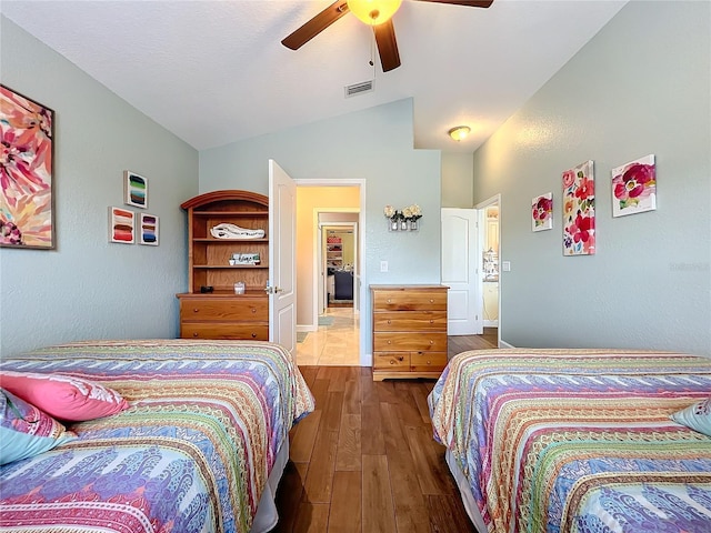 bedroom with ceiling fan, vaulted ceiling, and dark hardwood / wood-style floors