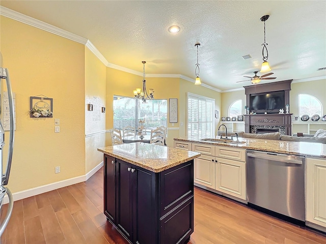 kitchen with light stone counters, sink, stainless steel dishwasher, and a center island with sink