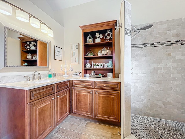 bathroom with vanity and a tile shower