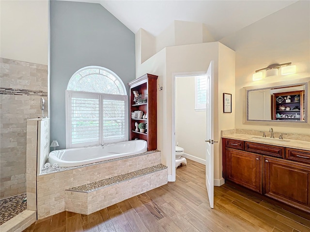 full bathroom featuring toilet, vanity, vaulted ceiling, hardwood / wood-style floors, and shower with separate bathtub