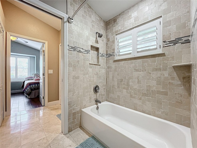 bathroom featuring tile patterned floors, lofted ceiling, and tiled shower / bath