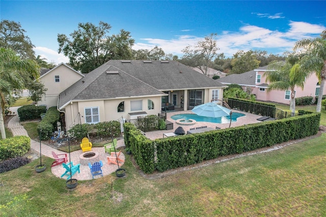 view of pool with an in ground hot tub, a patio area, a fire pit, and a lawn