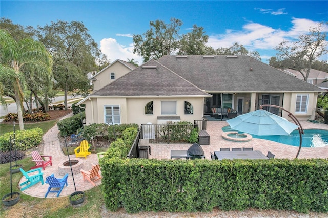 rear view of house with an outdoor fire pit and a patio