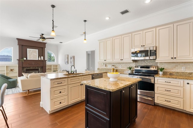 278 Eaglet Way, Lake Mary, FL 32746 - kitchen with appliances with stainless steel finishes, cream cabinets, a sink, a ceiling fan, and a peninsula