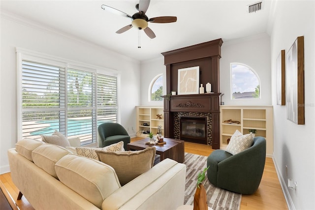 278 Eaglet Way, Lake Mary, FL 32746 - living area with a tiled fireplace, light wood-style flooring, ornamental molding, ceiling fan, and baseboards