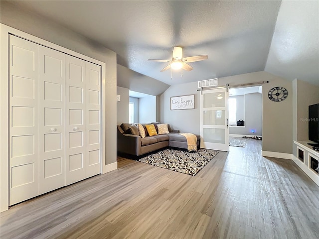 278 Eaglet Way, Lake Mary, FL 32746 - living room featuring wood finished floors, a ceiling fan, lofted ceiling, baseboards, and a barn door