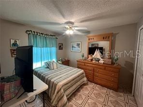 bedroom featuring a textured ceiling and ceiling fan