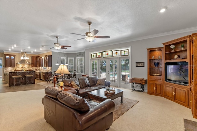 living room featuring crown molding, ceiling fan, a textured ceiling, light carpet, and french doors