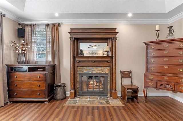 unfurnished room featuring a textured ceiling, a fireplace, wood finished floors, baseboards, and ornamental molding