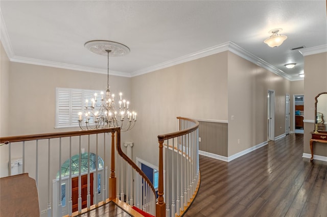 corridor with visible vents, wood finished floors, crown molding, an upstairs landing, and a chandelier