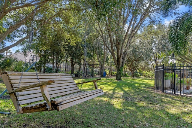 view of home's community with fence and a lawn