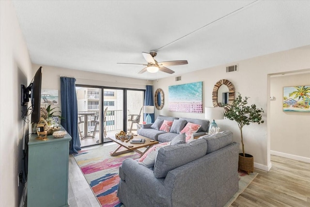 living room featuring wood-type flooring and ceiling fan