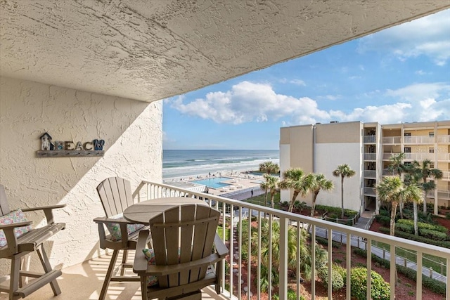 balcony featuring a water view and a view of the beach