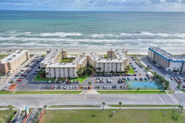 birds eye view of property with a water view and a beach view